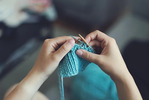 Manos tejiendo a crochet con hilo de colores